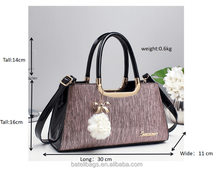 Structured glitter tote handbag in purple with black handles and white pom-pom charm