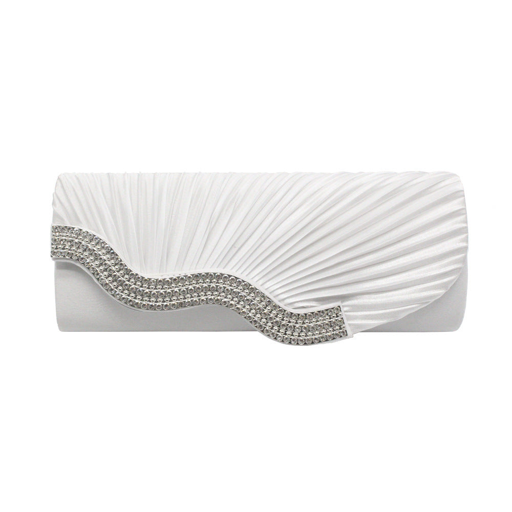 White pleated clutch with silver rhinestone zigzag trim along the flap