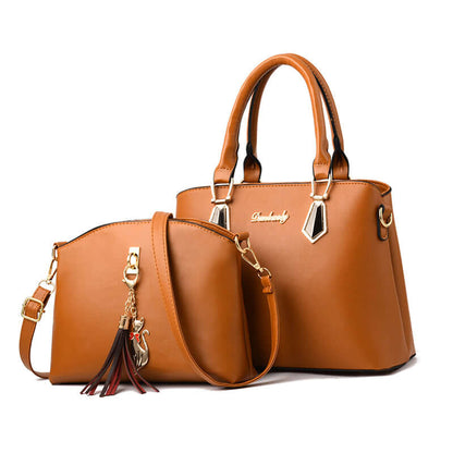 Tan faux-leather crossbody handbag with tassel charm, gold hardware, and twin top handles