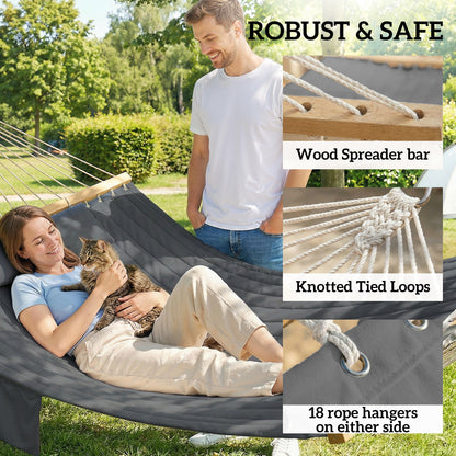 Gray two-person hammock in use with two people reclining, wooden spreader bars and rope ends