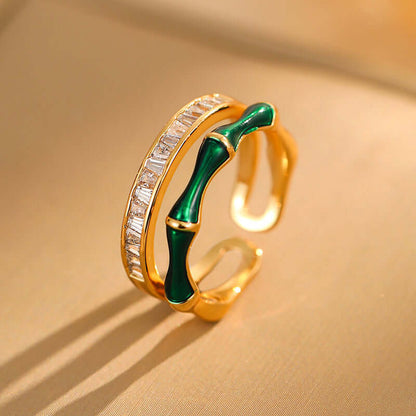 Gold-tone open ring with green enamel detail and zircon stones