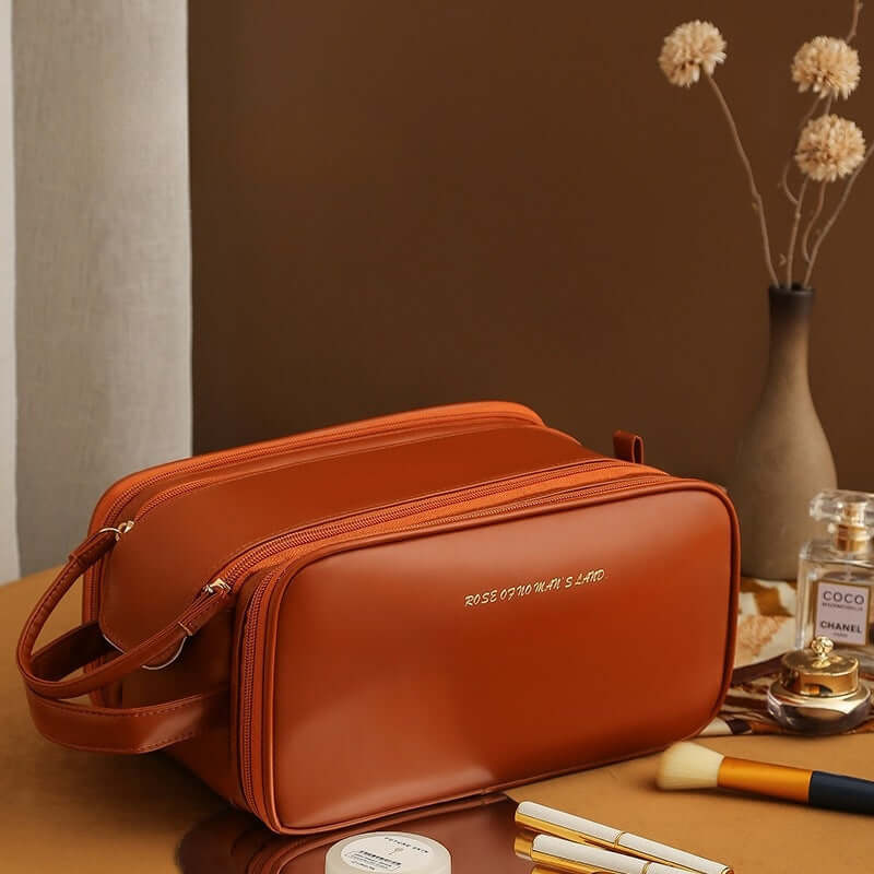 Orange-brown cosmetic bag with double zippers and a crossbody strap