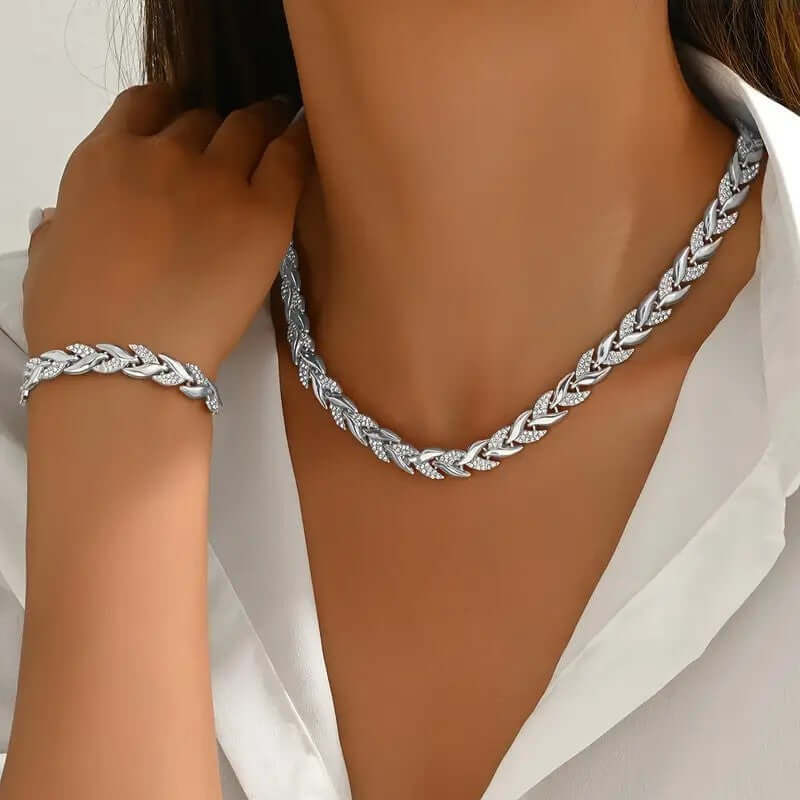 Rhinestone leaf necklace and bracelet set in silver tone, styled on model neckline and wrist.