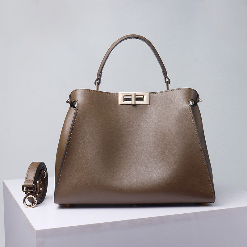 Taupe-brown crossbody handbag with top handle, gold-tone lock clasp and side flap pockets