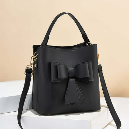 Black bow bucket crossbody bag with structured top handles and bow detail
