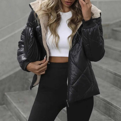 Person wearing a black puffer jacket with beige lining on a gray stone staircase.