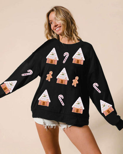 Woman wearing a black sweater with Christmas-themed designs on a beige background