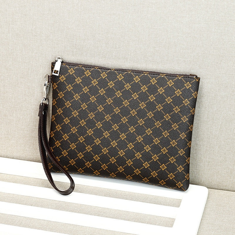 Brown monogram-style zip-top clutch with wrist strap and textured fabric weave