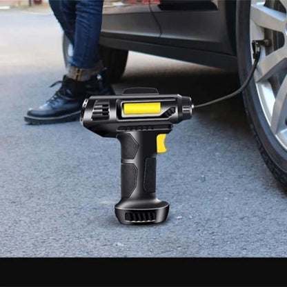 Black tire inflator on the ground near a car wheel, yellow window on barrel