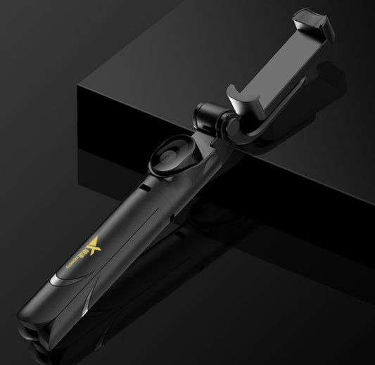 Black selfie stick with smartphone holder on a reflective black surface
