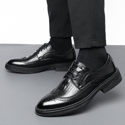 Black leather dress shoes worn with black pants on a gray background