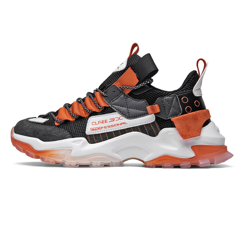 Platform sneaker with black mesh upper, orange laces and panels, and white chunky sole.