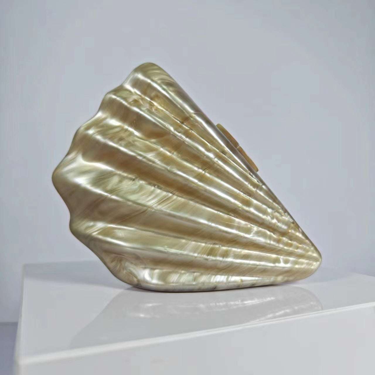 Metallic gold shell crossbody bag with glossy ridged design