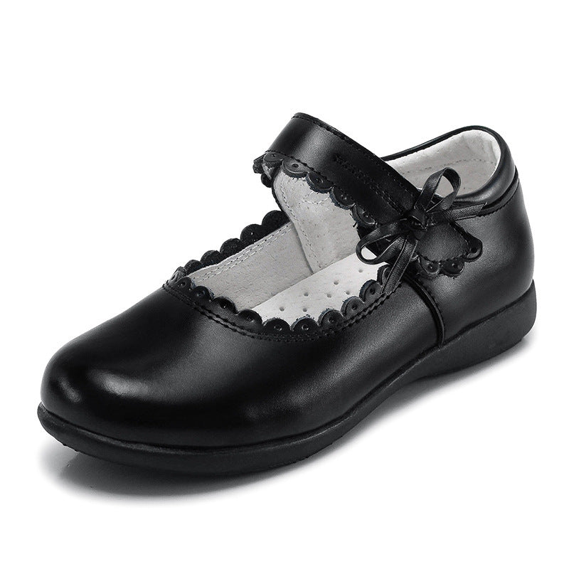 Black leather Mary Jane flats with scalloped edge and bow accent, low sole