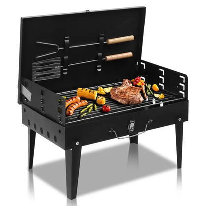 Black square charcoal grill with open lid, skewers and food-ready cooking surface
