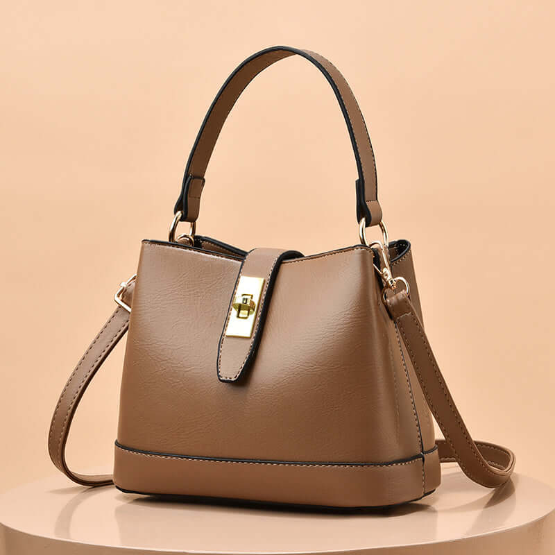 Tan tote handbag with shoulder strap and gold clasp hardware