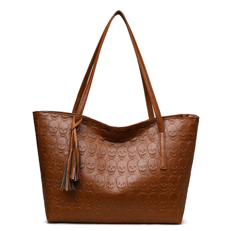 Brown embossed skull one-shoulder tote bag with tassel and open top