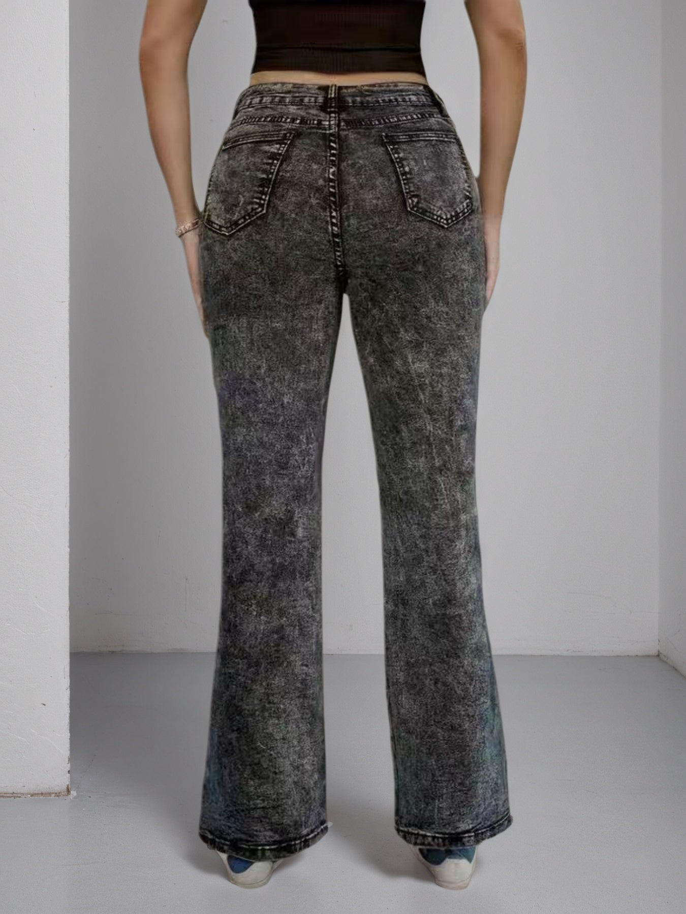 High-waisted dark jeans, wide flare cut, back view with side buckle hardware
