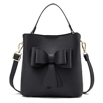 Black bow bucket crossbody bag with adjustable strap and gold-tone hardware