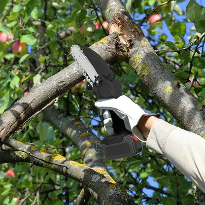 Cordless mini electric chainsaw cutting tree limbs; gloved hand on handle