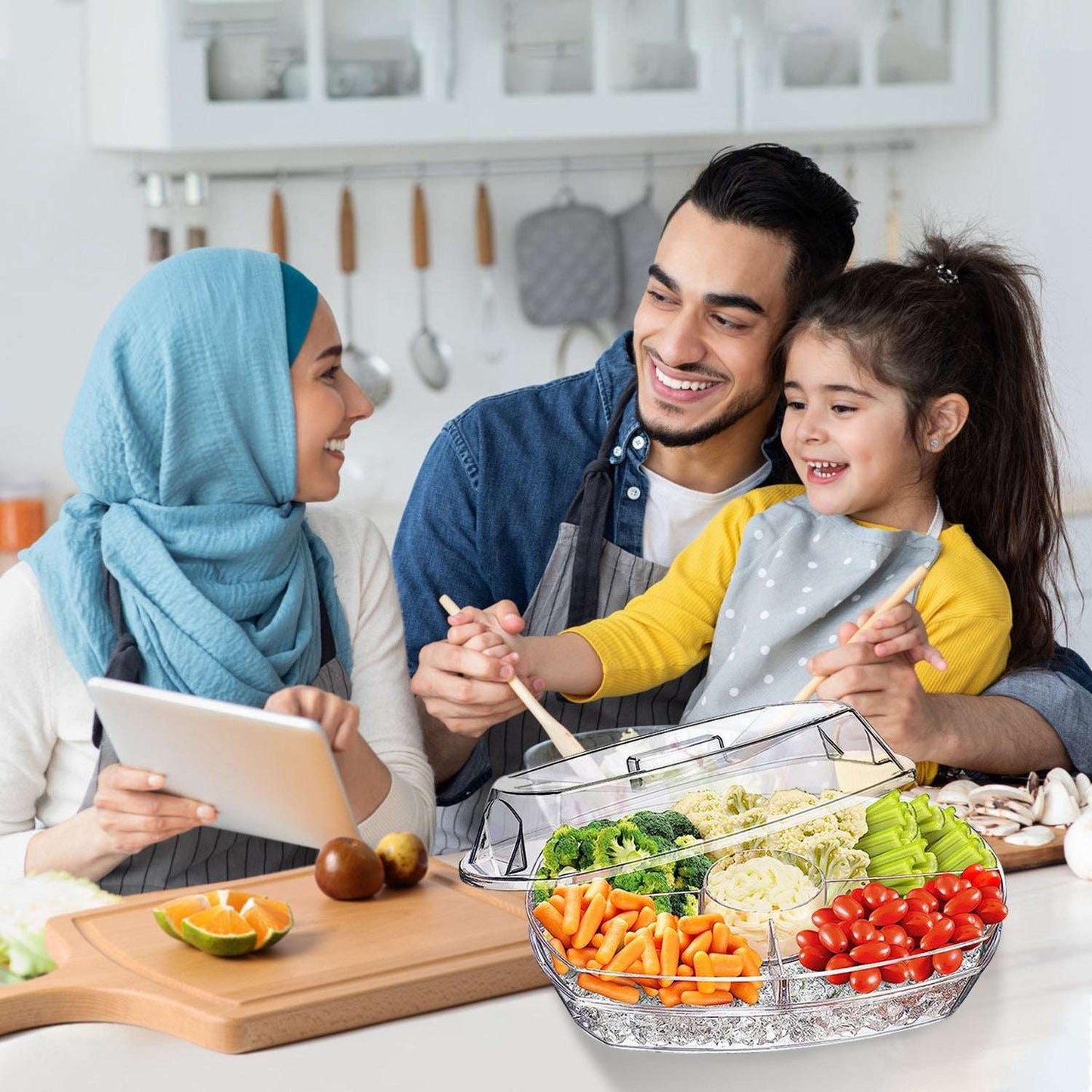 Clear divided veggie serving tray with mixed produce, placed on a wooden board