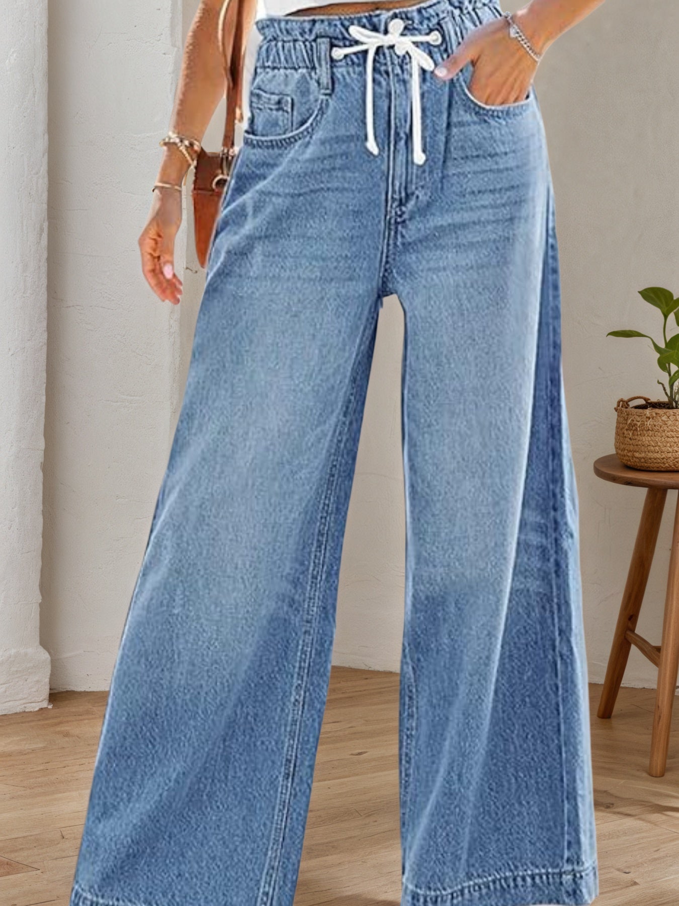 Light blue denim wide-leg bellbottom jeans with drawstring waist and front seams