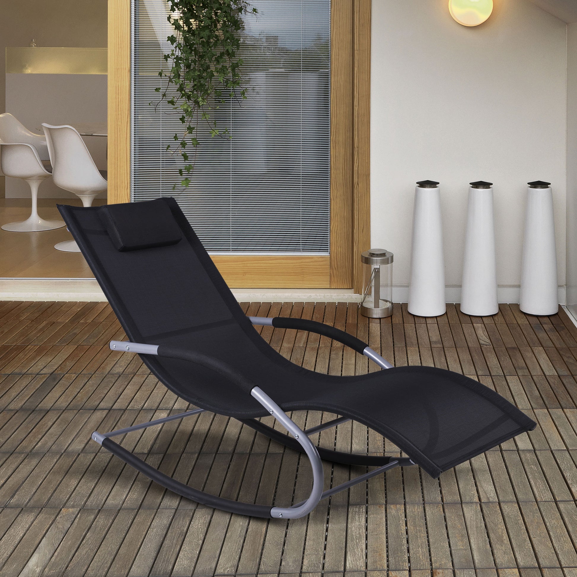 Black outdoor rocking lounge chair with curved rock base and padded head pillow