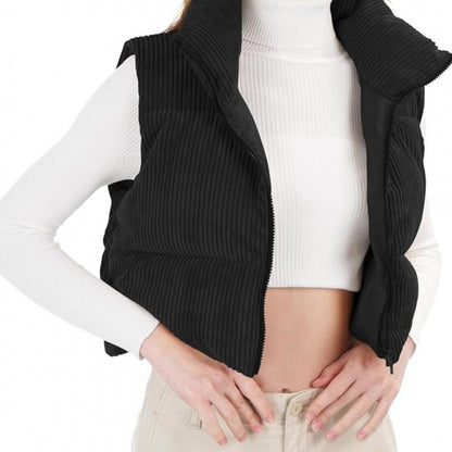 Person wearing a black ribbed vest over a white long-sleeve shirt on a white background
