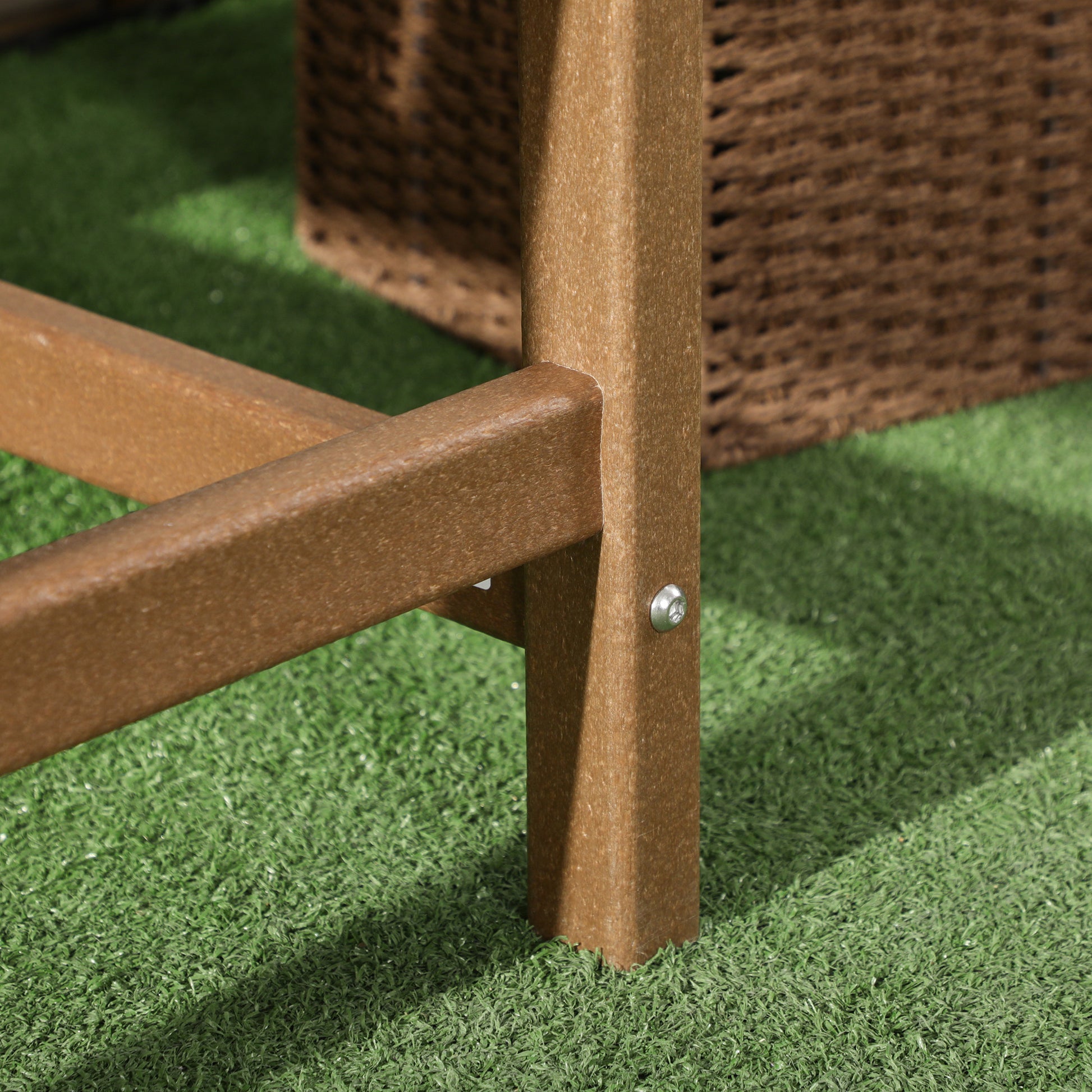 Brown chair corner leg with metal fastener; wood-like frame on outdoor mat.