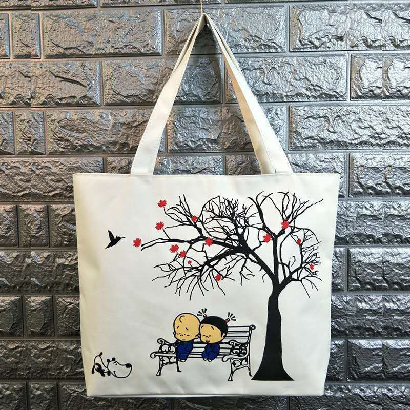 Canvas shoulder bag with black tree branches, red flowers, and small animal figures