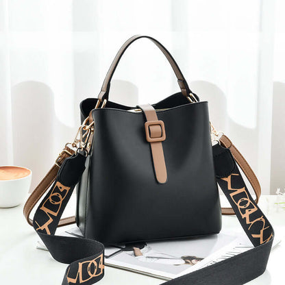 Black PU leather bucket bag with top handles, front buckle tab, and patterned crossbody strap