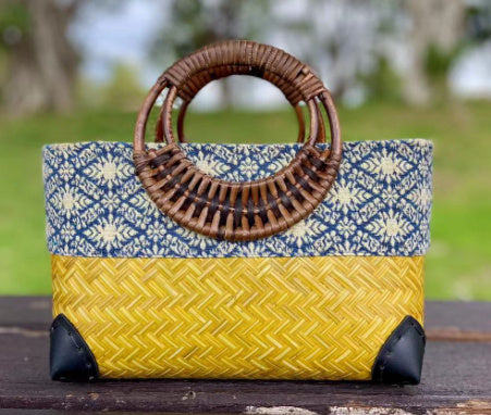 Woven bamboo handbag with brown handle, blue patterned top, yellow woven body