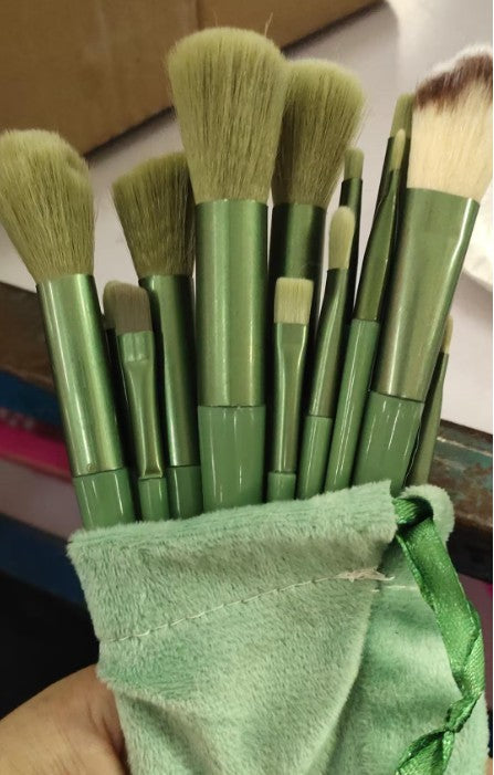 Makeup brush set with green handles and soft olive bristles, inside a green drawstring pouch.