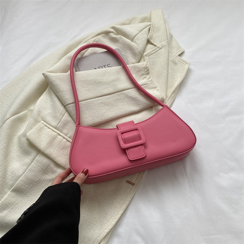 Small square crossbody bag, pink, curved flap with buckle strap and top handle.