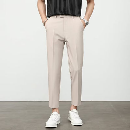 Light beige dress pants with belt loops, pleated front, and tapered legs