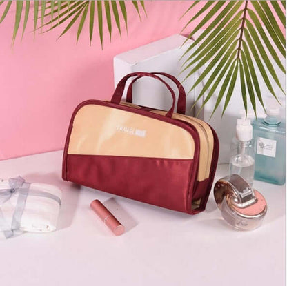 Cosmetic storage bag with maroon body, tan front panel, and top handle.