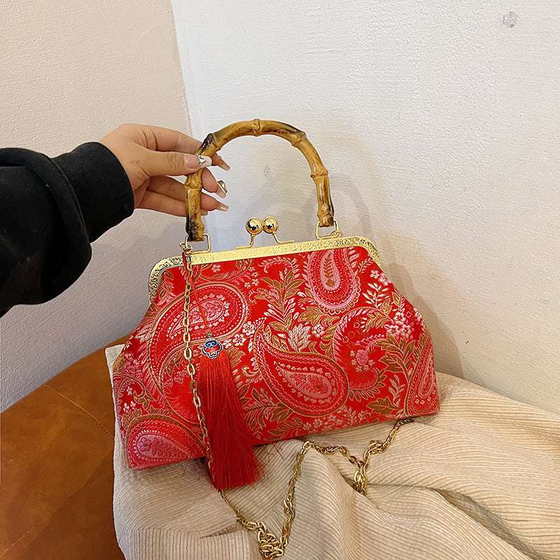 Red paisley satin clutch with bamboo handle, frame clasp, red tassel and gold chain
