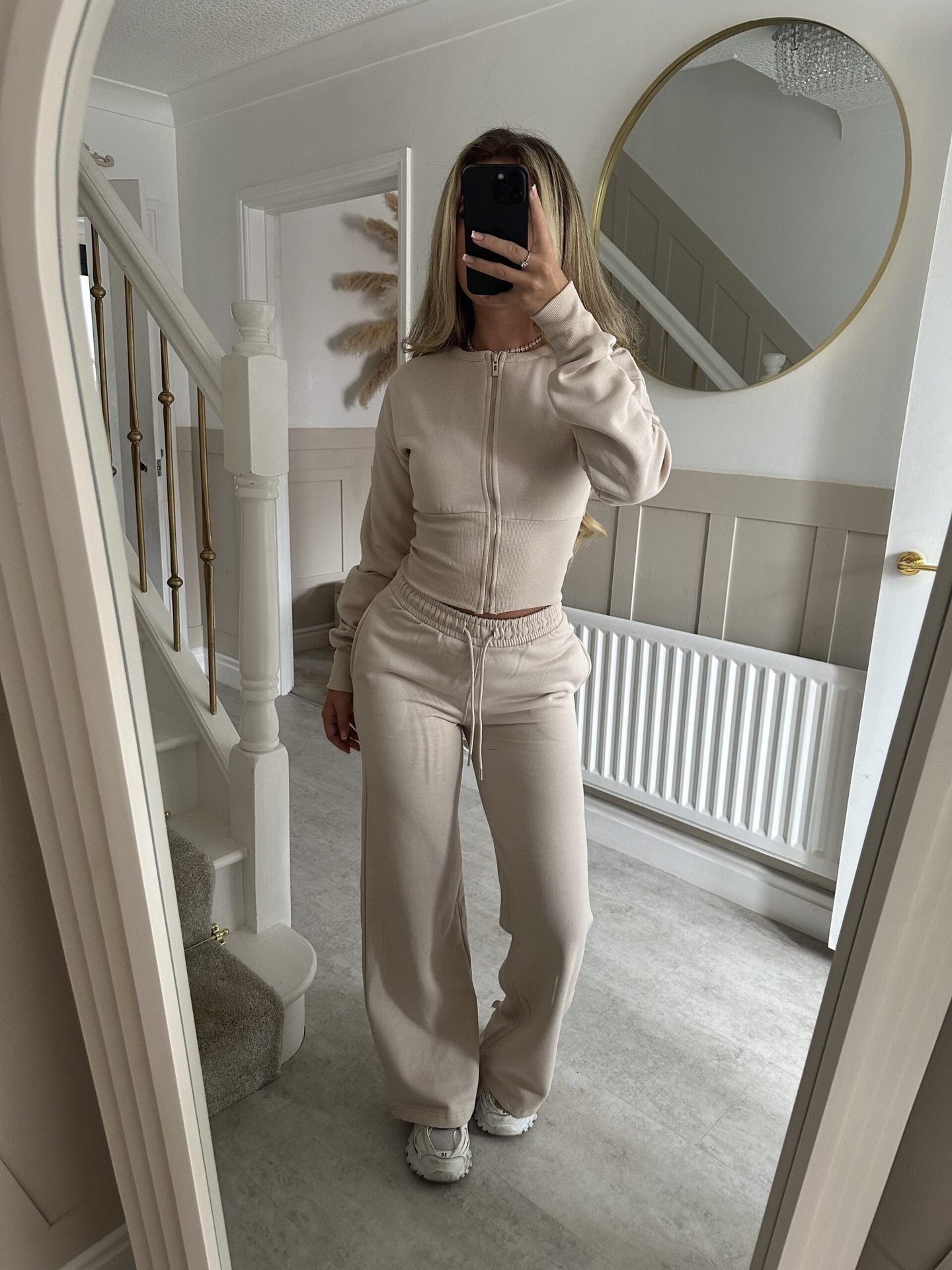 Women’s zip-front sweatshirt and jogger set in apricot beige, full-length two-piece.