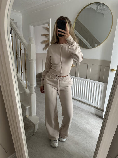 Women’s zip-front sweatshirt and jogger set in apricot beige, full-length two-piece.