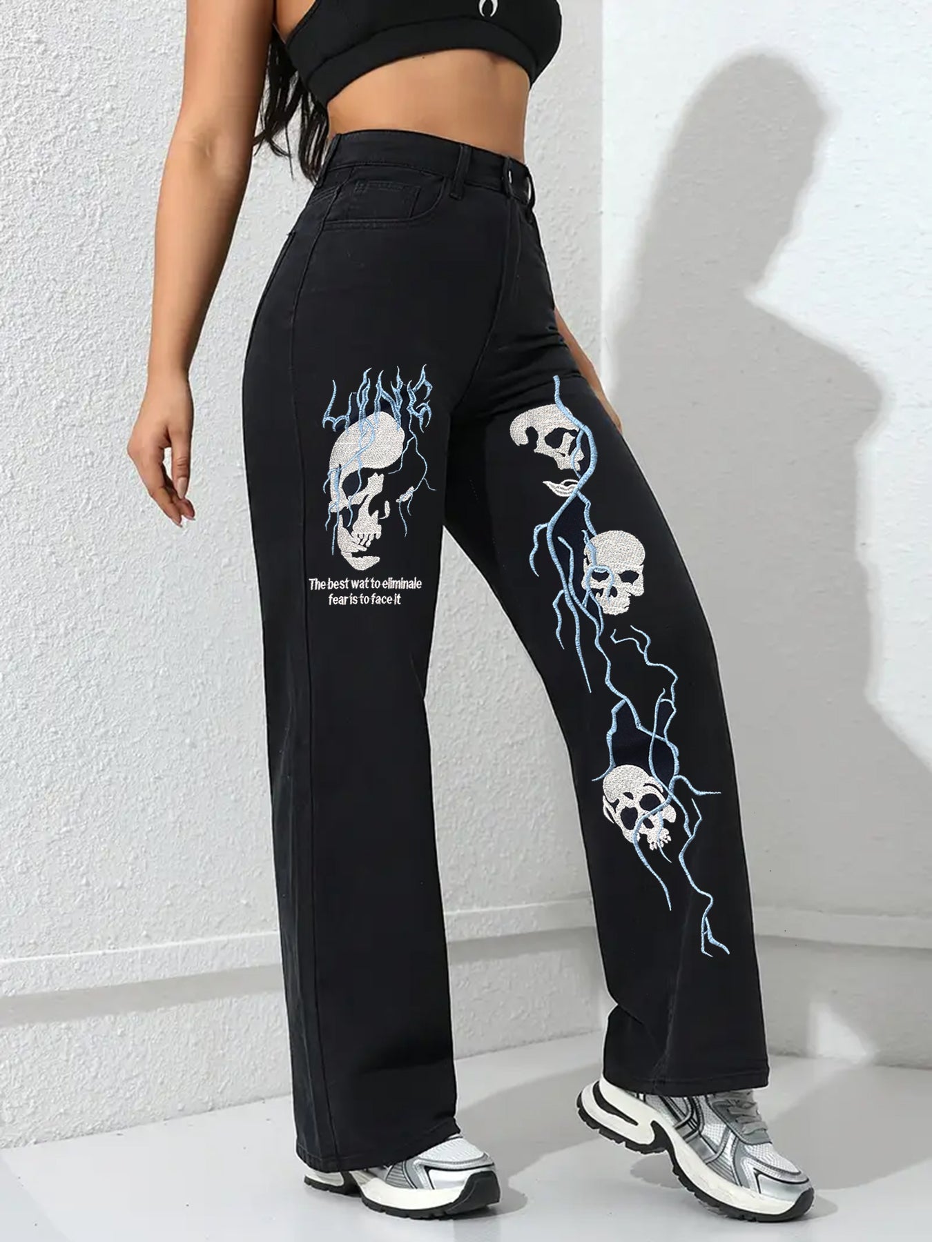 Black women’s jeans with tall skull-and-flame embroidery detail on wide legs
