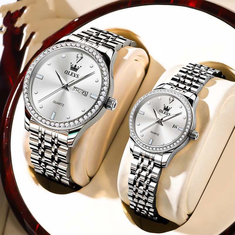Two white dial diamond bezel watches with silver metal link bracelets on display