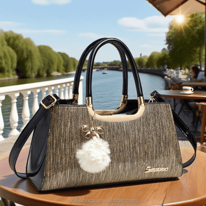 Structured glitter tote handbag with black handles and white pom-pom charm