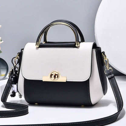 Lightweight crossbody bag with white and black colorblock, top handle, flap, gold clasp, strap