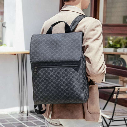 Gray patterned backpack worn on back with front zipper pocket and padded straps