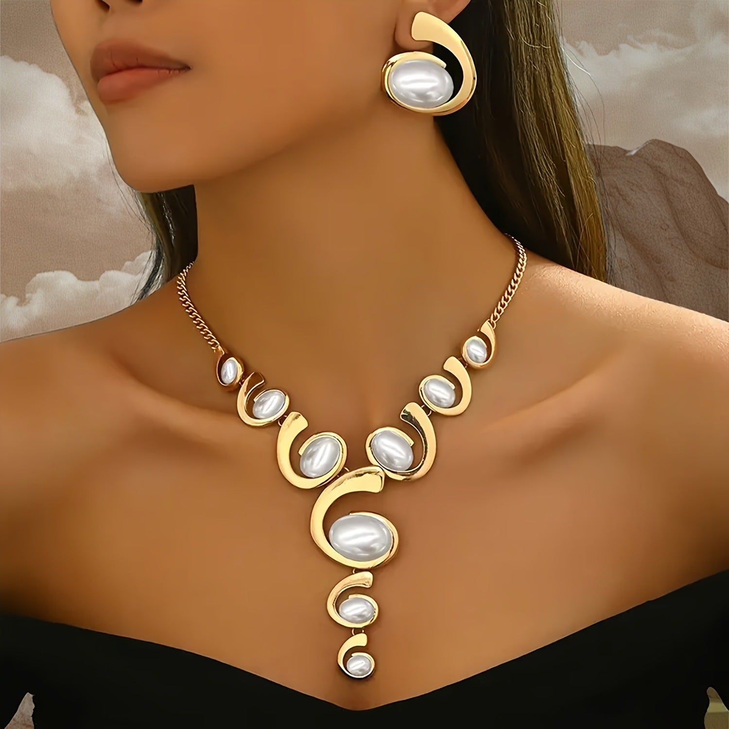 Single snail-shaped earring with gold-tone frame and white oval pearl-like center