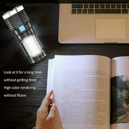Black rechargeable LED flashlight with blue indicator, shining near an open book