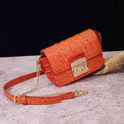 Orange one-shoulder crossbody bag with textured finish and gold-tone clasp, chain strap.