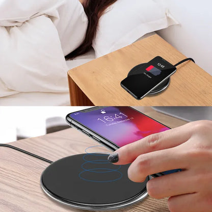 Black Qi wireless charger on wooden side table with smartphone on top