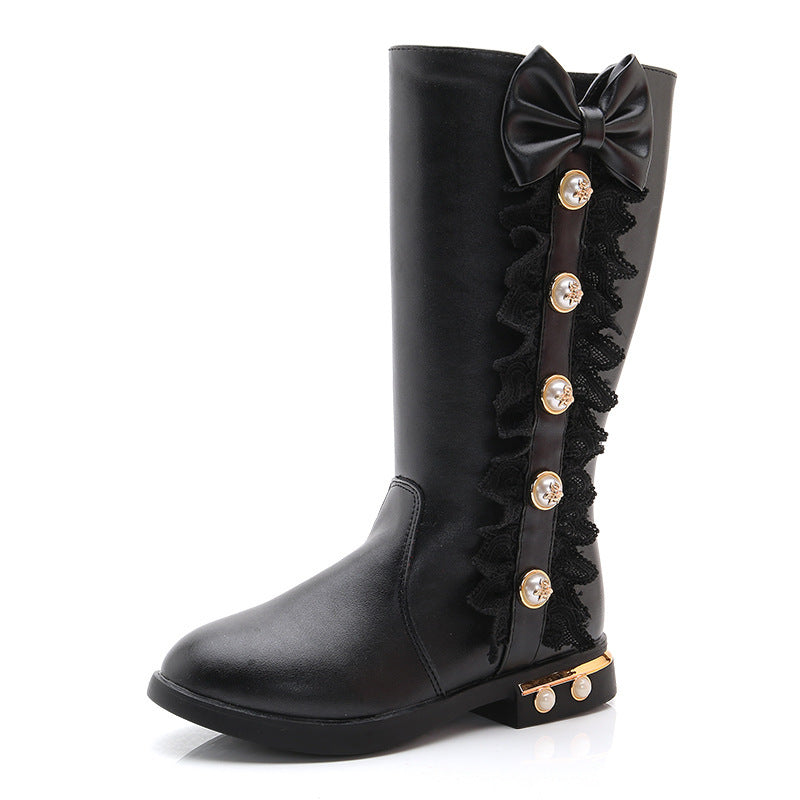 Girls' fleece-lined boots in black with large bow, ruffled side trim, and gold accents