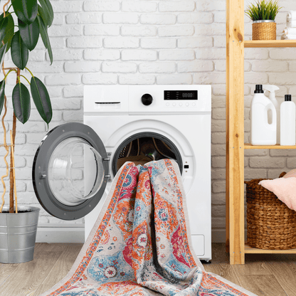 Washable area rug folded on a front-load washer, cream with blue and orange pattern